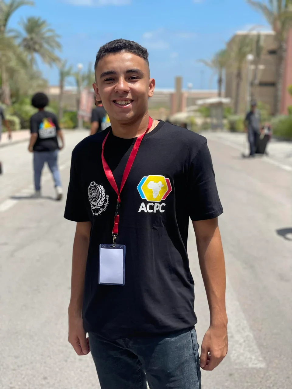 Ayman at a programming competition, photographed outdoors.